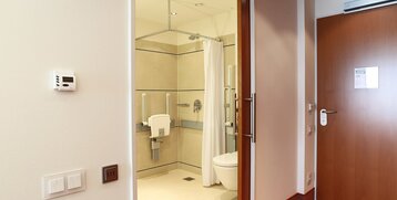 Blick durch die Tür zum Badezimmer des Standard Zimmer barrierefrei des ATLANTIC Hotel Wilhelmshaven