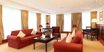 Wohnzimmer der Kaiser Wilhelm Suite mit Sofas und großen Fenstern im ATLANTIC Hotel Wilhelmshaven