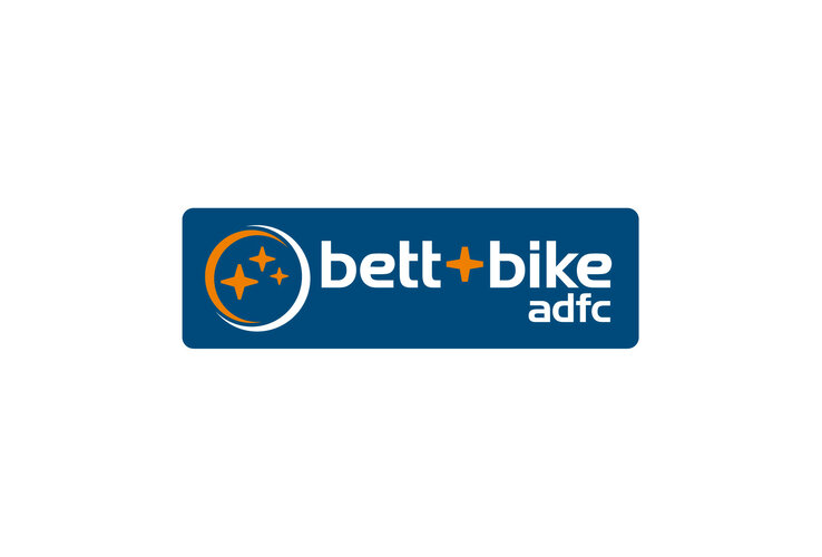 Logo von "bett+bike adfc" auf blauem Hintergrund mit orangefarbenen Sternen.