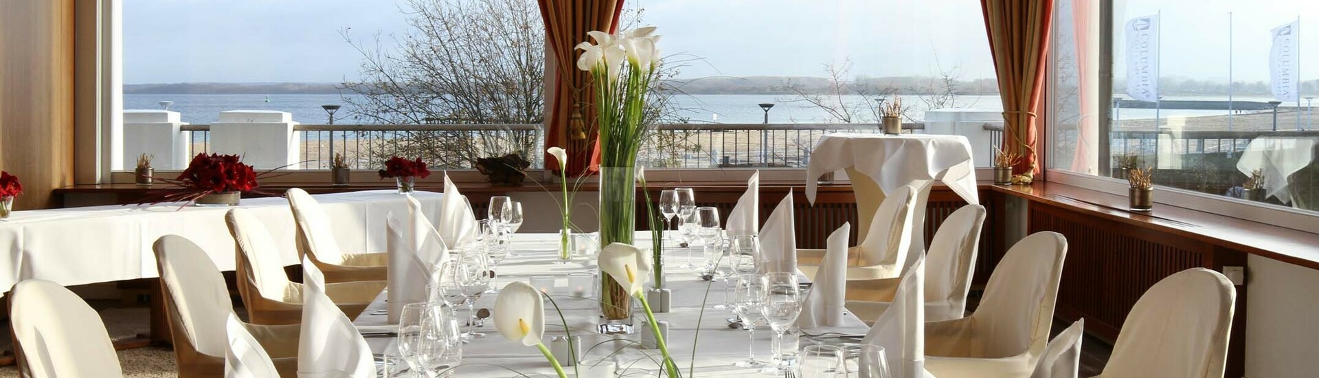 Event room Travemünde with a view over the Baltic Sea Elegant restaurant with table setting, large windows and sea view at the ATLANTIC Grand Hotel Travemünde.