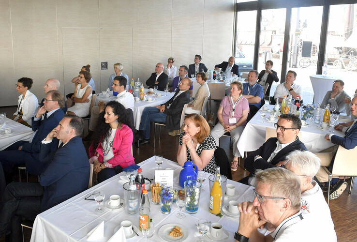 Personengruppe bei einer Konferenz im ATLANTIC Hotel Sail City, Bremerhaven, in einem hellen Raum mit gedeckten Tischen.