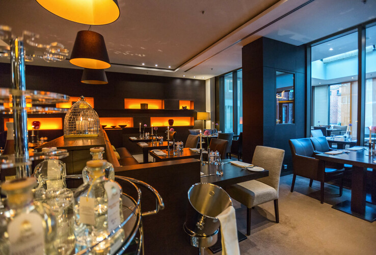 Elegantes Hotelrestaurant mit modernen Möbeln, warmem Licht und gedeckten Tischen im ATLANTIC Grand Hotel Bremen.
