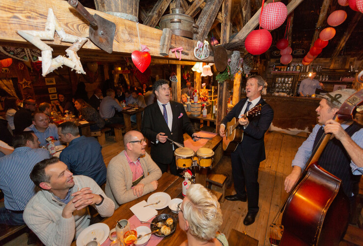 Gemütliches Restaurant im ATLANTIC Grand Hotel Bremen mit Live-Musik und geselligen Gästen an Holztischen.