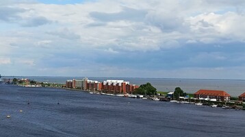 View of the port of Wilhelmshaven with red brick buildings, water and cloudy sky.