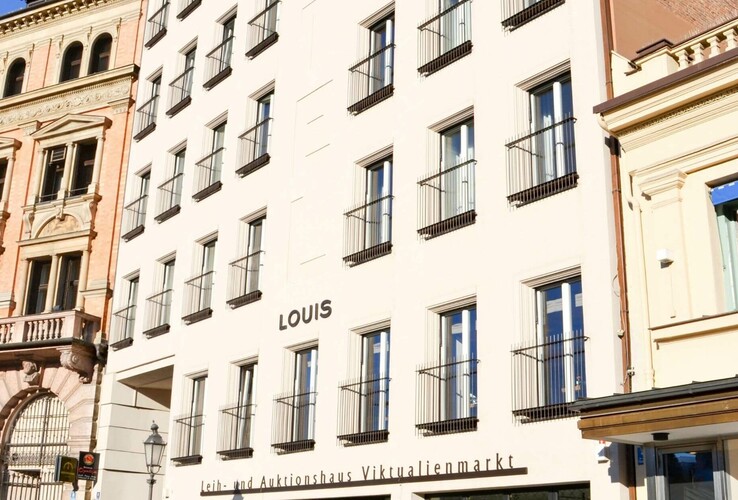 LOUIS Hotel München Façade of a hotel with many windows and the lettering "LOUIS" in a historic building environment.