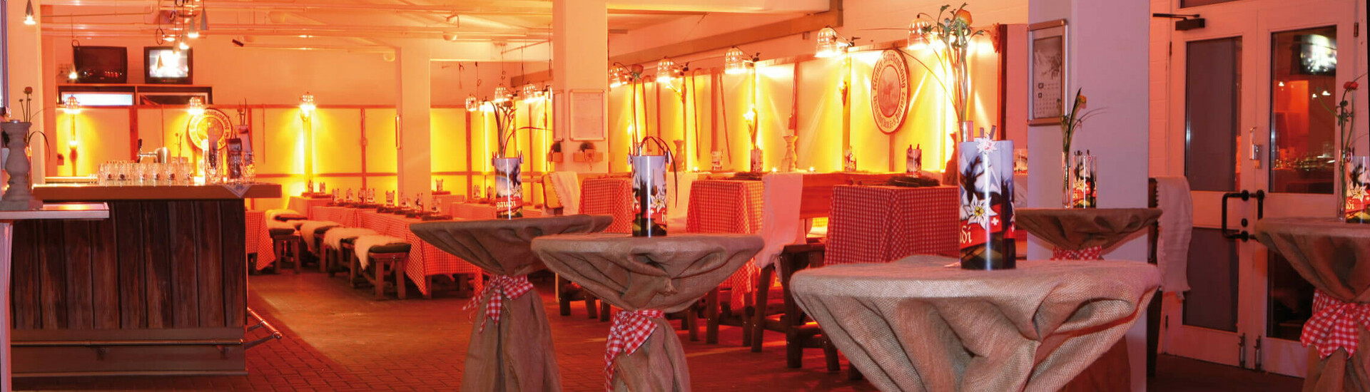 Die festlich dekorierte Wetthalle im ATLANTIC Hotel an der Galopprennbahn Gemütlicher Veranstaltungsraum mit Stehtischen, rustikaler Dekoration und warmem, stimmungsvollem Licht im ATLANTIC Hotel.