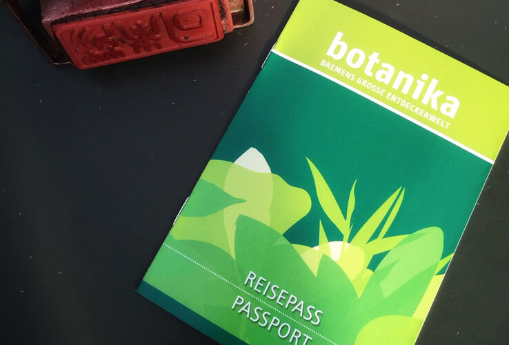 Green "botanika" passport with plant motif and red stamp on dark background.
