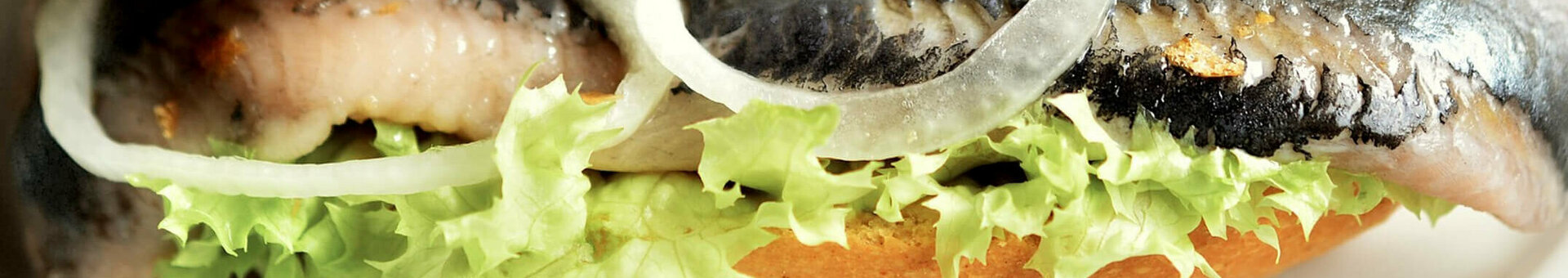 Frisches Fischbrötchen mit Zwiebeln und Salat auf knusprigem Brötchen.