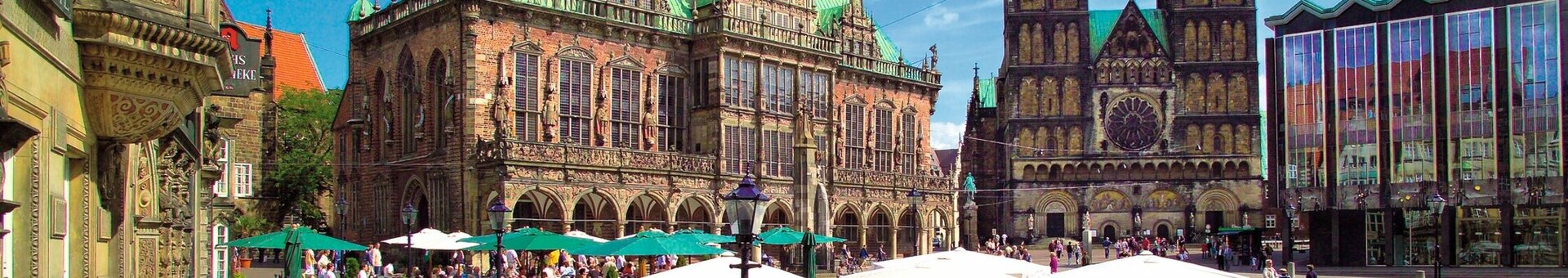Bremer Marktplatz im Sommer Belebter Platz mit historischem Gebäude, Dom und Café-Terrasse unter Sonnenschirmen bei blauem Himmel.