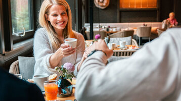 Ein fröhliches Paar frühstückt im ATLANTIC Hotel Landgut Horn 