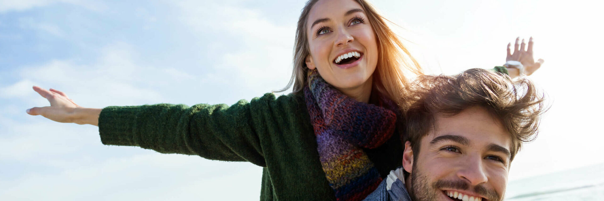 A smiling couple enjoys the sunny beach, which conveys joy and relaxation at the ATLANTIC Grand Hotel Travemünde.
