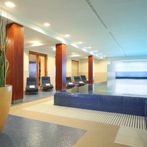 Schwimmbad Helles Hallenbad mit Liegestühlen und Pflanzen im ATLANTIC Grand Hotel Travemünde.