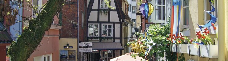 Colorful alley in the Schnoorviertel Bremen, half-timbered houses, decorations and plants, inviting and picturesque.