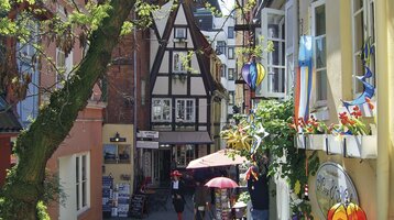 Colorful alley in the Schnoorviertel Bremen, half-timbered houses, decorations and plants, inviting and picturesque.