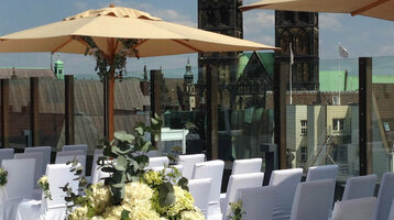 Dachterrasse des ATLANTIC Grand Hotel Bremen, festlich dekoriert für eine Veranstaltung mit Blick auf Kirchtürme.