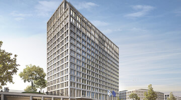 Modern high-rise hotel with glass facade, surrounded by trees and people on the street under a clear sky.