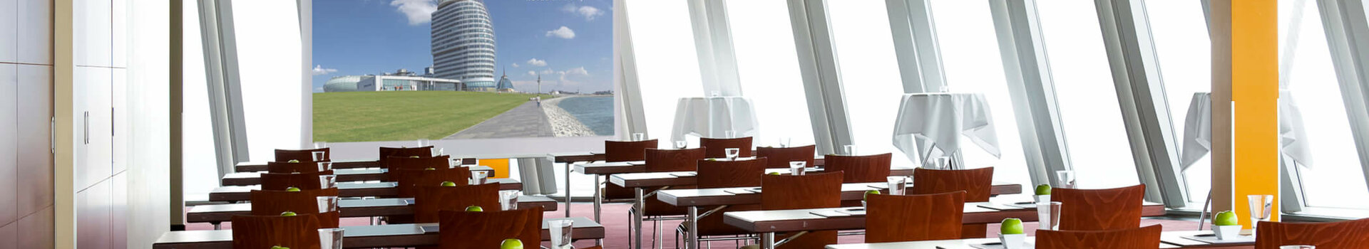 Heller Konferenzraum im ATLANTIC Hotel Sail City, Bremerhaven, mit Tischen, Stühlen und grünen Äpfeln als Dekoration.