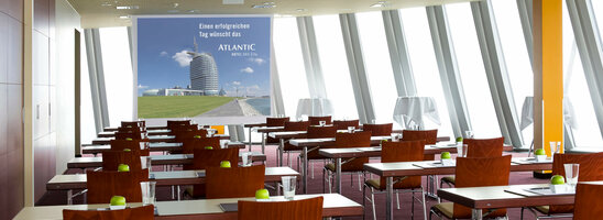 Heller Konferenzraum im ATLANTIC Hotel Sail City, Bremerhaven, mit Tischen, Stühlen und grünen Äpfeln als Dekoration.