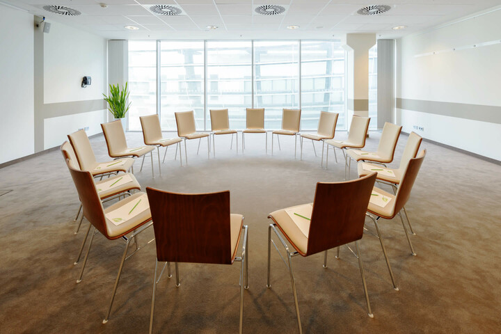 Bright conference room in the ATLANTIC Hotel, circle of chairs, large windows, modern furnishings.