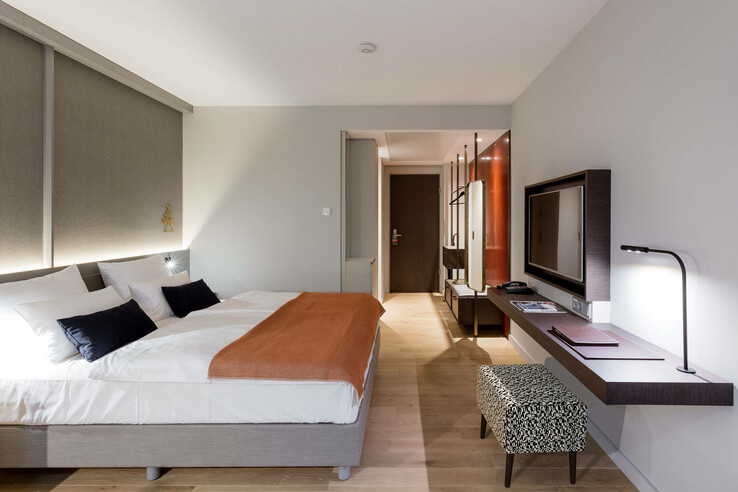 Modern hotel room with double bed, desk, TV and stylish lighting at the ATLANTIC Grand Hotel Bremen.