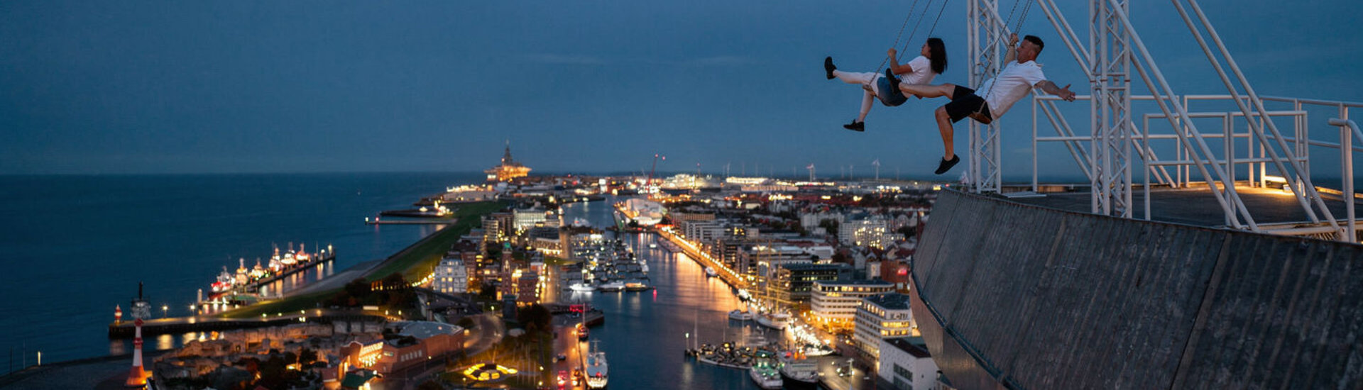 Zwei Personen die auf der High Swing auf dem ATLANTIC Hotel Sail City Schaukeln. KI Mockup