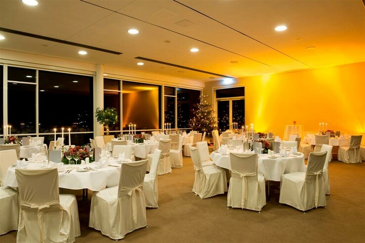 Festlich dekorierter Bankettsaal im ATLANTIC Hotel Galopprennbahn mit runden Tischen und Kerzenlicht.