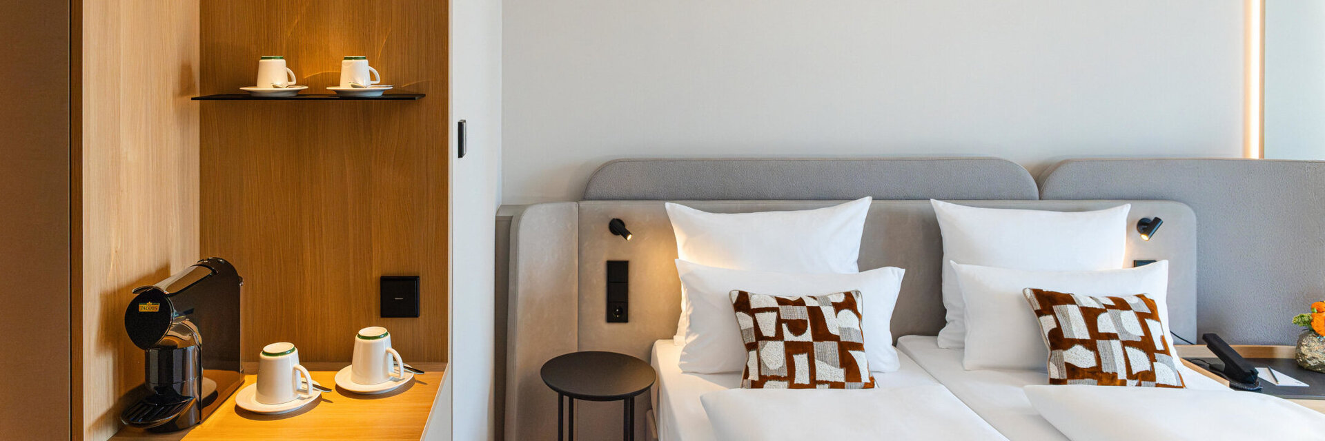 A bed in a Superior Double Room and the coffee station with its warm wooden tones.