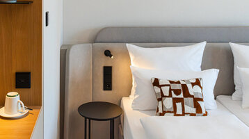 Bett im Superior Doppelzimmer und die Kaffeestation mit warmen Holztönen.