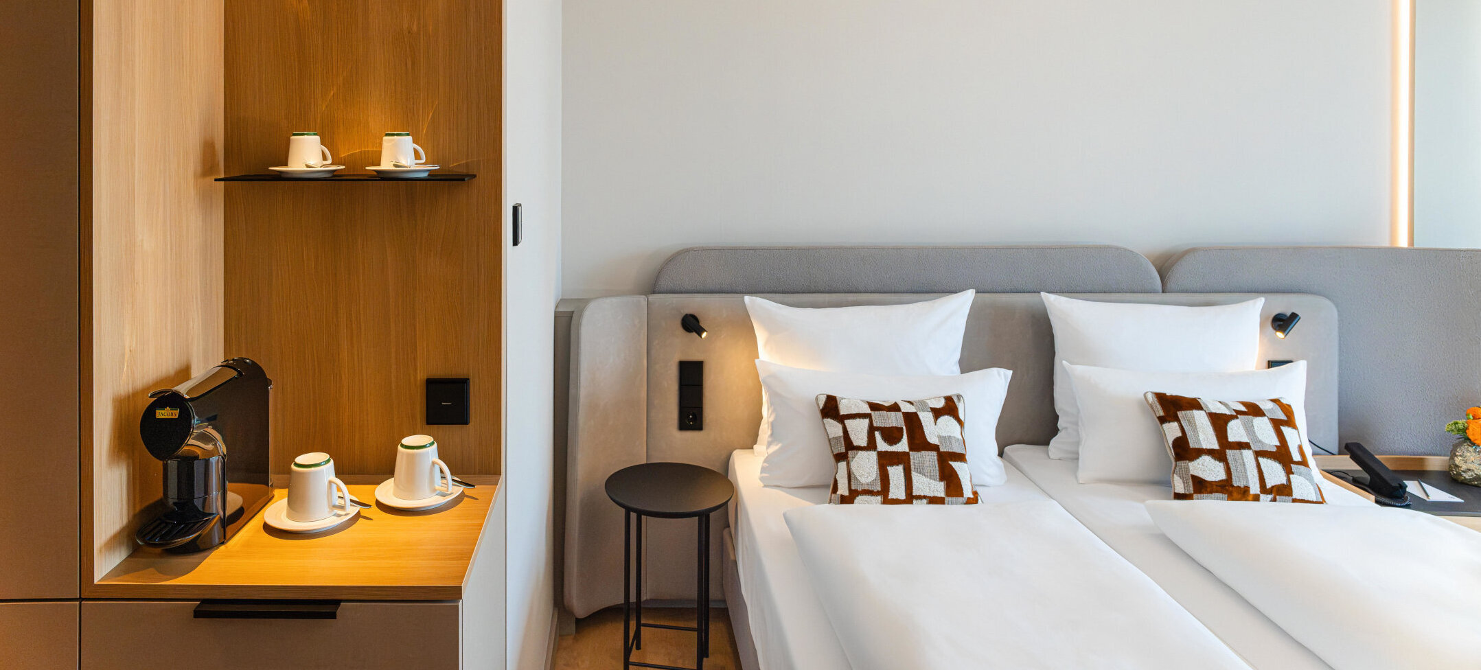 A bed in a Superior Double Room and the coffee station with its warm wooden tones.