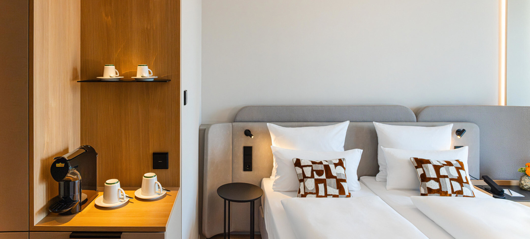 Bett im Superior Doppelzimmer und die Kaffeestation mit warmen Holztönen.