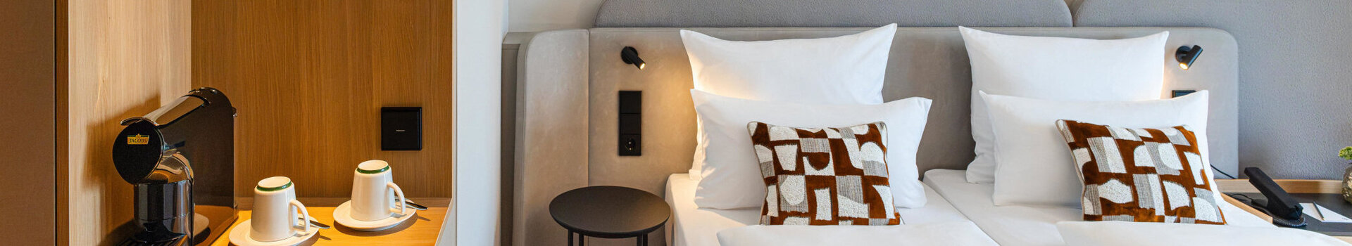 Bett im Superior Doppelzimmer und die Kaffeestation mit warmen Holztönen.