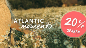 Frau mit Strohhut in Blumenwiese, Text "Atlantic Moments", Rabattangebot "20% sparen" in rotem Kreis.