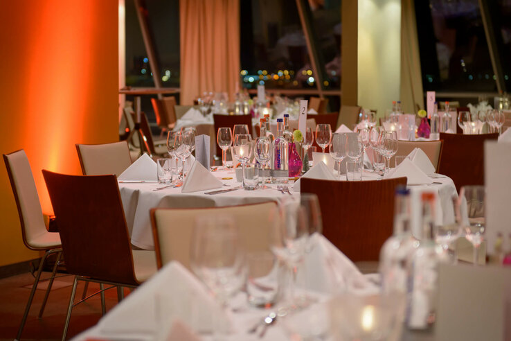Elegant hotel restaurant with white-clothed tables, glasses and soft lighting at the ATLANTIC Hotel Sail City.