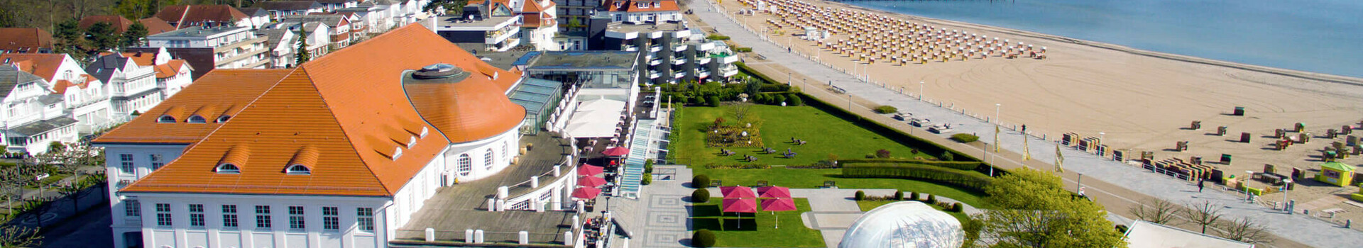 Luftaufnahme des ATLANTIC Grand Hotel Travemünde mit Strandzugang und Meerblick an einem sonnigen Tag.