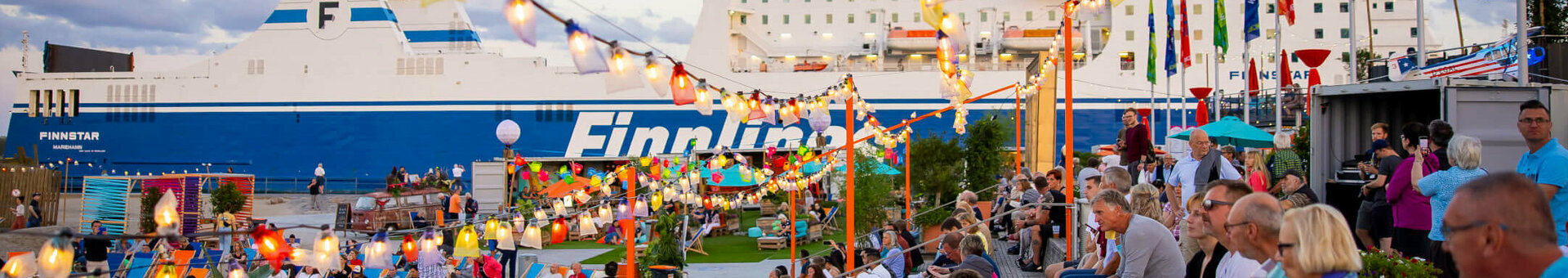 ATLANTIC Grand Hotel Travemünde Weite Welt Festival Personen an der festlich geschmückten Promenade von Travemünde, Finnline Fähre im Hintegrund