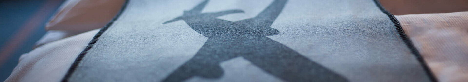 Bedspread in the ATLANTIC Hotel Airport Bremen with airplane motif, blurred window view in the background.
