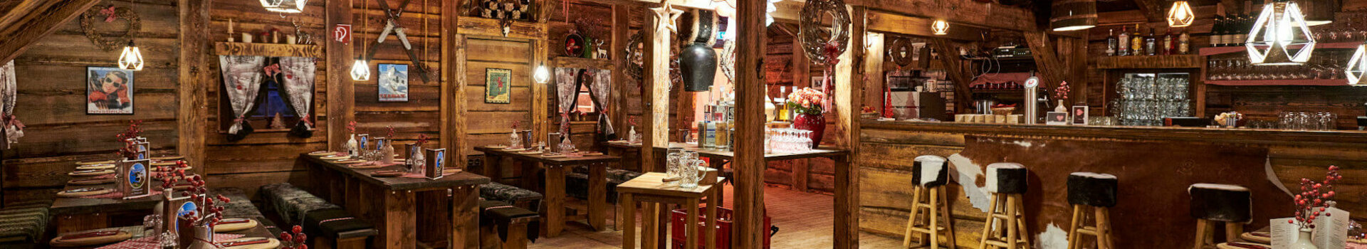 Rustikales Restaurant im ATLANTIC Grand Hotel Bremen mit Holzmöbeln, gemütlicher Beleuchtung und dekorativen Elementen.