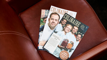 Three "Culinaire" magazines on a brown leather armchair in the ATLANTIC Grand Hotel Bremen.