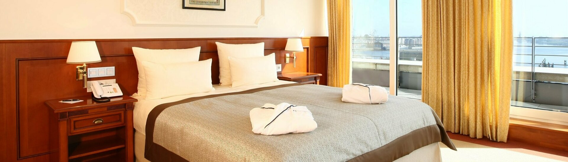 Bedroom of the Kaiser Wilhelm Suite with a big bed and a view over the harbour in the ATLANTIC Hotel Wilhelmshaven Bedroom of the Kaiser Wilhelm Suite with a big bed and a view over the harbour in the ATLANTIC Hotel Wilhelmshaven