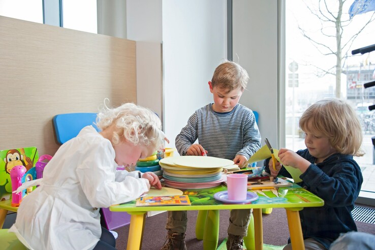 Kinder basteln und malen an einem kleinen Tisch im ATLANTIC Hotel Kiel.