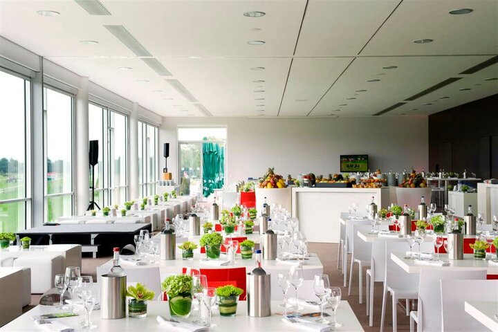 Bright, modern function room with covered tables, large windows and a view of the racecourse.