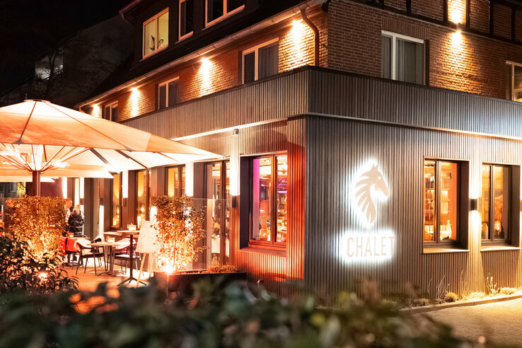 Das Restaurant CHALET stilvoll beleuchtet bei Nacht.