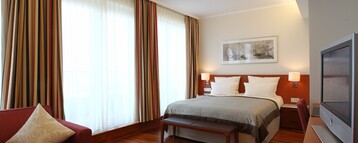 Schlafzimmer mit großem Bett im Executive Zimmer des ATLANTIC Hotel Wilhelmshaven
