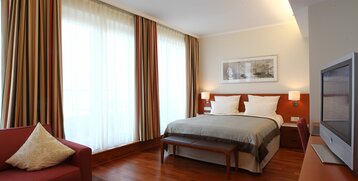 Schlafzimmer mit großem Bett im Executive Zimmer des ATLANTIC Hotel Wilhelmshaven