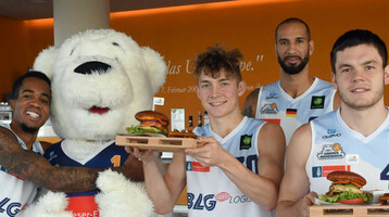 Eisbären Bremerhaven im ATLANTIC Hotel Sail City Basketballspieler posieren mit Maskottchen und Burgern im ATLANTIC Hotel Sail City, Bremerhaven.