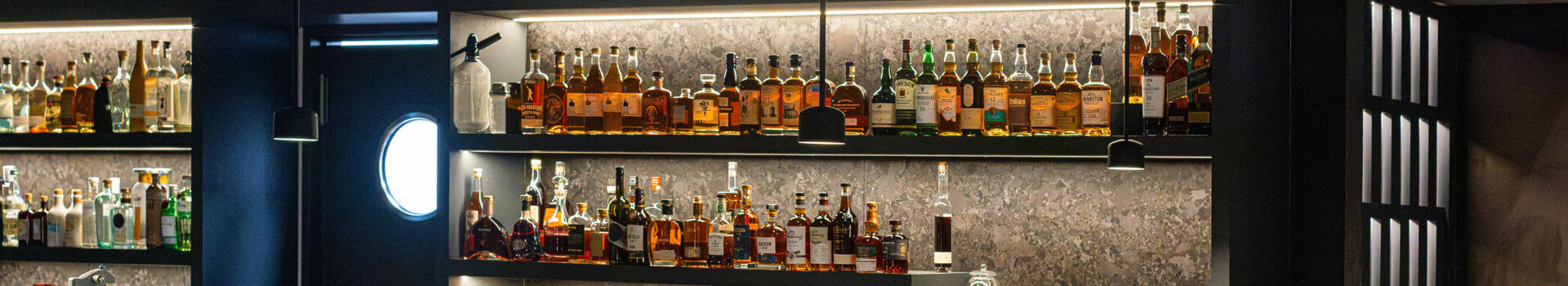 A view of the bar counter with bottles and glasses at the 20 High Skyline Bar.