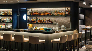 A view of the bar counter with bottles and glasses at the 20 High Skyline Bar.
