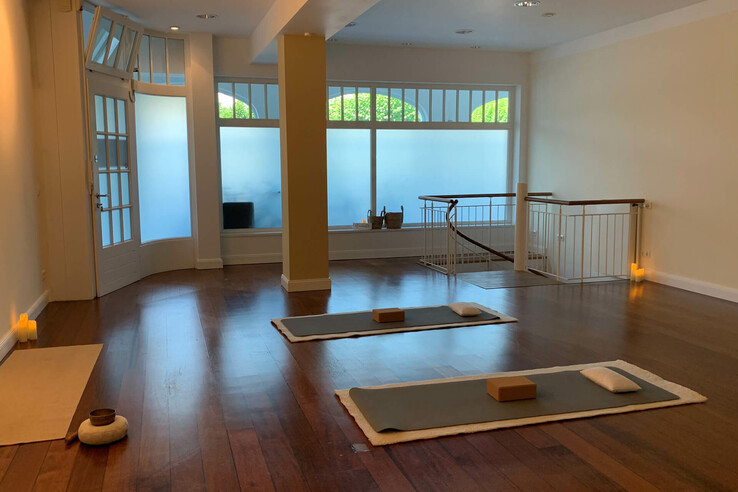 Heller Yoga-Raum mit Holzboden, Matten, Kissen und Kerzen im ATLANTIC Grand Hotel Travemünde.