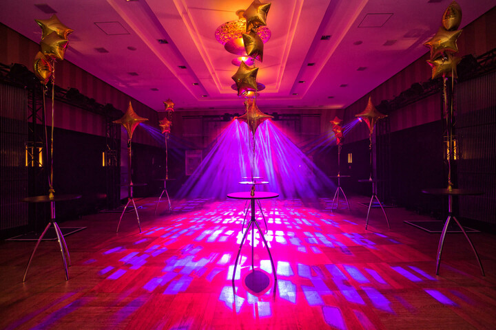 The Goldener Saal of the ATLANTIC Grand Hotel Bremen as an dance floor Event room in the ATLANTIC Grand Hotel Bremen with purple lighting and golden star balloons.