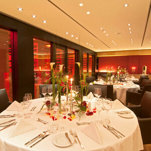 Runde Tische im Weinkeller im ATLANTIC Hotel Kiel Elegantes Restaurant im ATLANTIC Hotel Kiel mit stilvoll gedeckten Tischen, Kerzenlicht und moderner, warmer Beleuchtung.